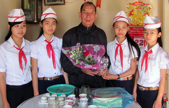 Học sinh Truờng THCS Lê Văn Tâm tặng hoa anh hùng Nguyễn Thành Khối.