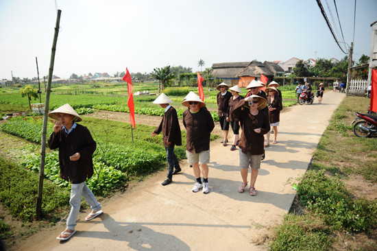 Du khách mặc áo nông dân cùng trẫy hội làng. Ảnh Minh Hải