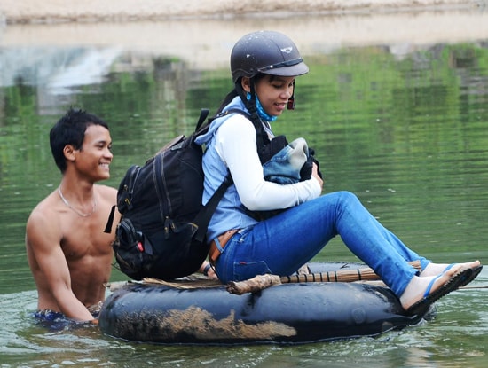 Anh Hồ Văn Tiêm dùng ruột xe đưa em gái Hồ Thị Hang vượt sông trở về lại nóc Tắc Rối.Ảnh: HỮU PHÚC