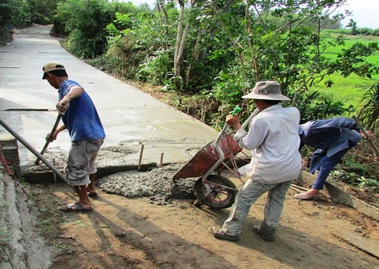 Góp sức dân bê tông hóa đường nông thôn và phát triển hệ thống kênh mương nội đồng.                          Ảnh: Hữu Phúc