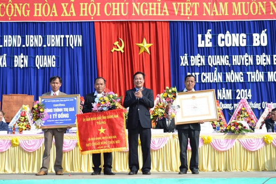 Phó Chủ tịch UBND tỉnh Huỳnh Khánh Toàn trao quyết định công nhận xã Điện Quang đạt chuẩn nông thôn mới 2014.         Ảnh: CÔNG TÚ