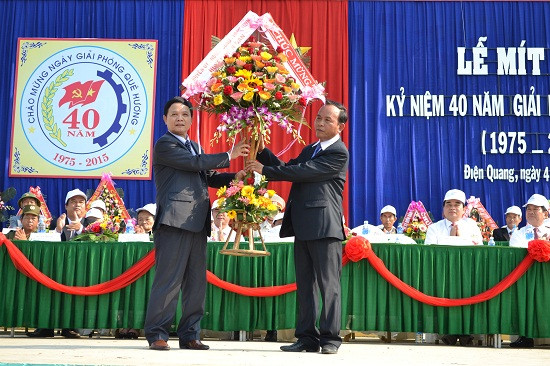 Bí thư Huyện ủy Điện Bàn - ông Lê Thân (đứng bên trái) tặng hoa chúc mừng. 