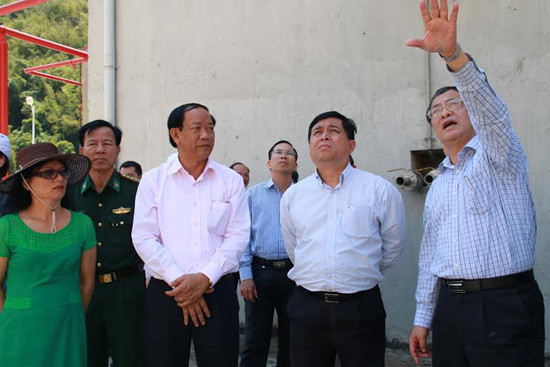 Thứ trưởng Nguyễn Chí Dũng (giữa) và Chủ tịch UBND tỉnh Đinh Văn Thu nghe nhà thầu báo cáo tiến độ thi công dự án. Ảnh: HUỲNH CHÍN