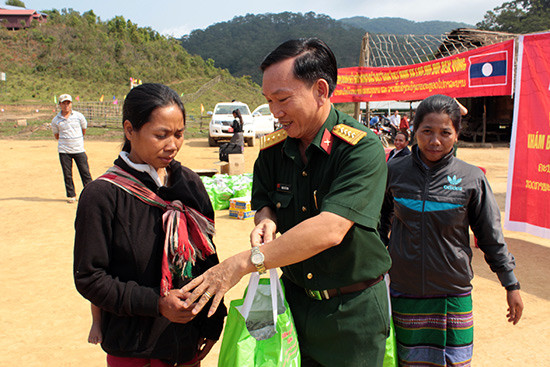 Đại tá Đoàn Thế Tùng, Phó Chính ủy Bộ CHQS tỉnh tặng quà cho bà con các bộ tộc Lào anh em. Ảnh: THANH TUẤN
