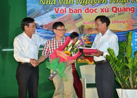 Nhà văn Nguyễn Nhật Ánh nhận hoa và quà từ Phó Chủ tịch UBND tỉnh Nguyễn Chín cùng Hội VHNT.