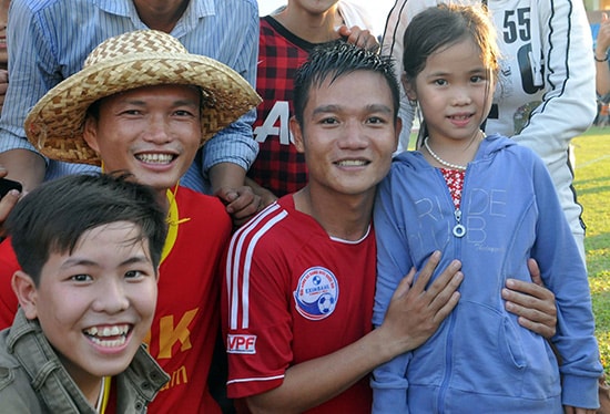 Đinh Thanh Trung trong vòng vây của người hâm mộ sau khi đội QNK Quảng Nam giành quyền thăng hạng ở mùa giải 2013.Ảnh: AN NHI