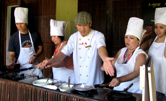 Đầu bếp Lê Thanh Tú ở làng rau Trà Quế đang dạy làm bánh xèo cho du khách.