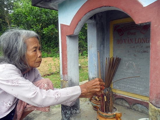 Cụ Nguyễn Thị Dần bên mộ chồng. Ảnh: NHƯ TRANG