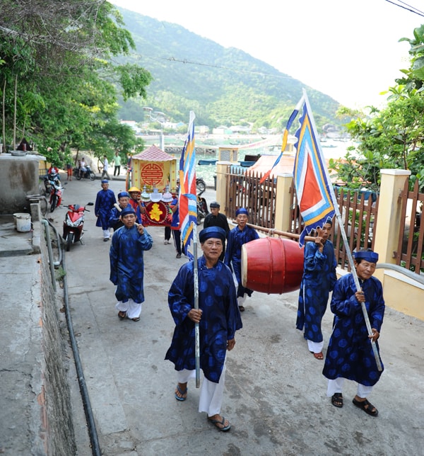 Các bô lão trong trang phục chỉnh tề, cờ phướn và kiệu đi các lang để nghinh thần. Ảnh Minh Hải