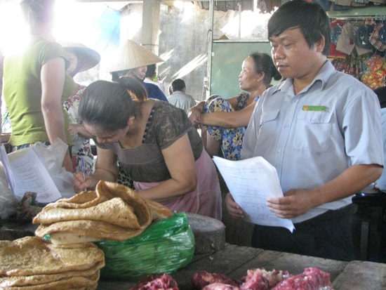 Đoàn kiểm tra liên ngành làm việc với tiểu thương kinh doanh thịt tại chợ Thanh Quýt (Điện Thắng Trung, Điện Bàn). Ảnh: P.H.N