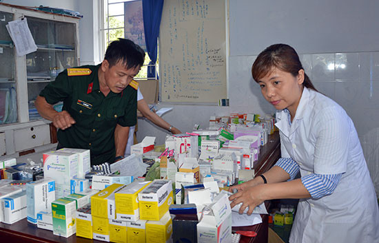 Chuẩn bị thuốc để cấp phát miễn phí cho người dân xã Bình Giang, Thăng Bình. Ảnh: DƯƠNG LÊ