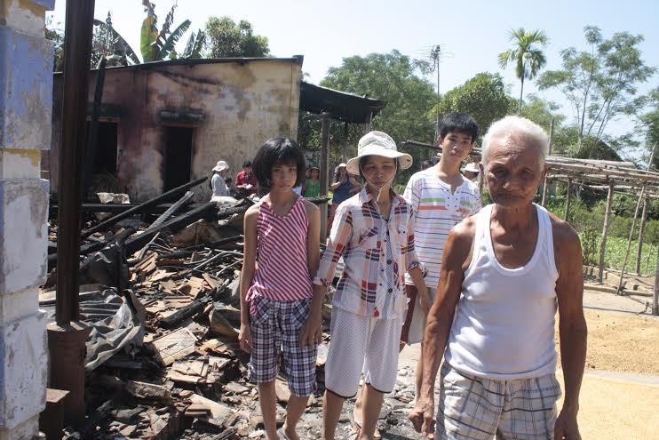 Cụ Trung và gia đình con trai bên căn nhà cháy rụi.