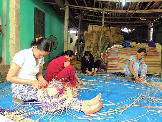  Phụ nữ làng chiếu Trà Nhiêu sản xuất sản mũ, túi xách... từ cói.