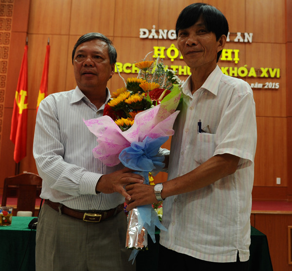 Ông Nguyễn Sự phải tặng hoa chúc mừng tân Bí thư thành ủy Hội An Kiều Cư. Ảnh Minh Hải