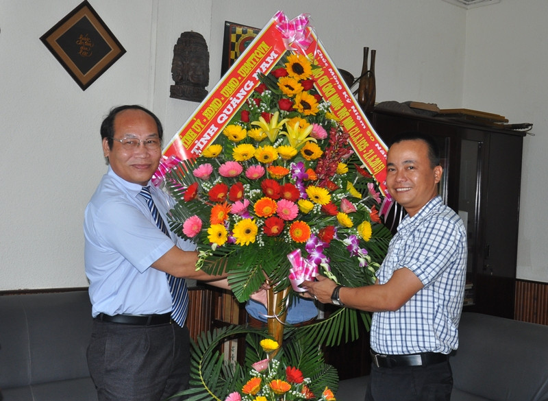 Chủ tịch Ủy ban MTTQ Việt Nam tỉnh Võ Xuân Ca tặng hoa chúc mừng Báo Lao động. Ảnh: VINH ANH