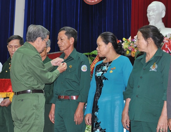 Đại diện Ban Thường vụ Hội Cựu TNXP tỉnh trao Huy hiệu Cựu TNXP tiên tiến làm theo lời Bác của Trung ương hội cho hội viên. Ảnh: V.ANH