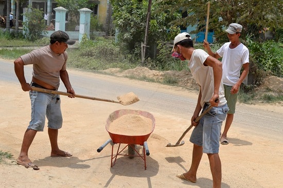 Tài xế xúc dọn bụi đất do mình chở để rơi xuống.