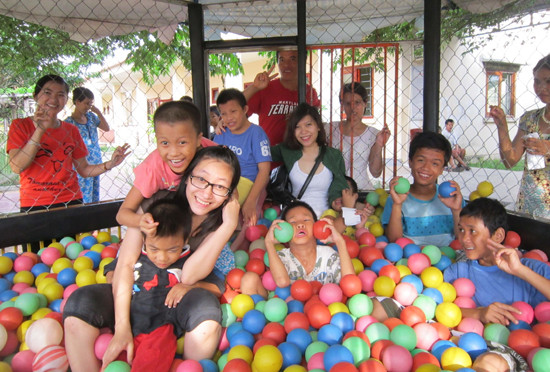 Các tình nguyện viên trẻ vui chơi với trẻ em nhiễm chất độc da cam ở Làng Hòa Bình. 