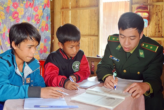 Trẻ em vùng biên học chữ cùng thầy giáo mang quân hàm xanh. Ảnh: ALĂNG NGƯỚC