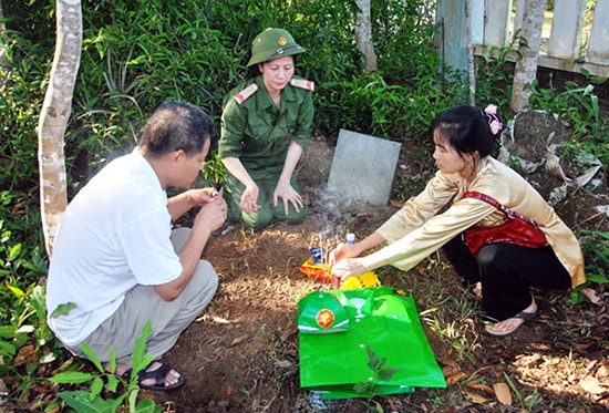 Các con của liệt sĩ Nguyễn Mạnh Thắng bên mộ bố trước khi khai quật. Ảnh: Đ.NGỌC