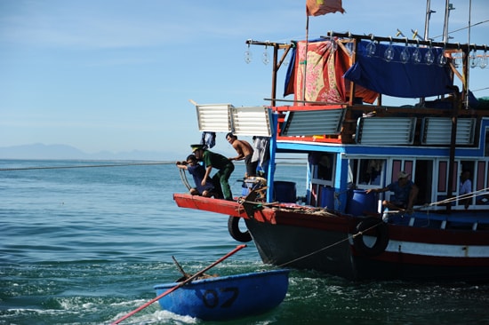 Cán bộ, chiến sỹ Biên phòng Cửa Đại cùng thuyền viên tàu 90207 nổ lực đưa tàu ra khỏi vùng cạn. Ảnh Minh Hải