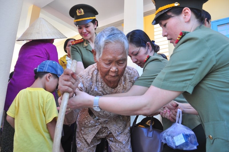 Các nữ Công an ân cần dìu dắt người già. Ảnh: VINH ANH