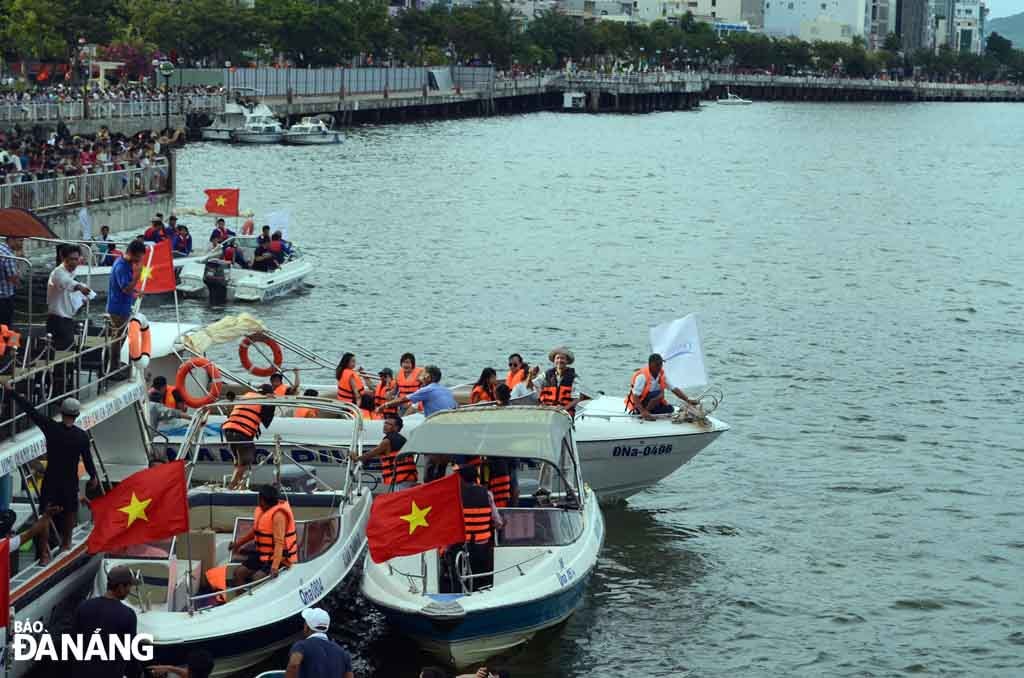 Đông đảo người dân đứng ở vỉa hè chờ đợi các vận động viên biểu diễn.
