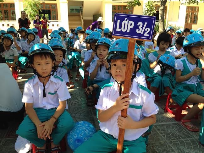 Trao mũ bảo hiểm cho các em học sinh.