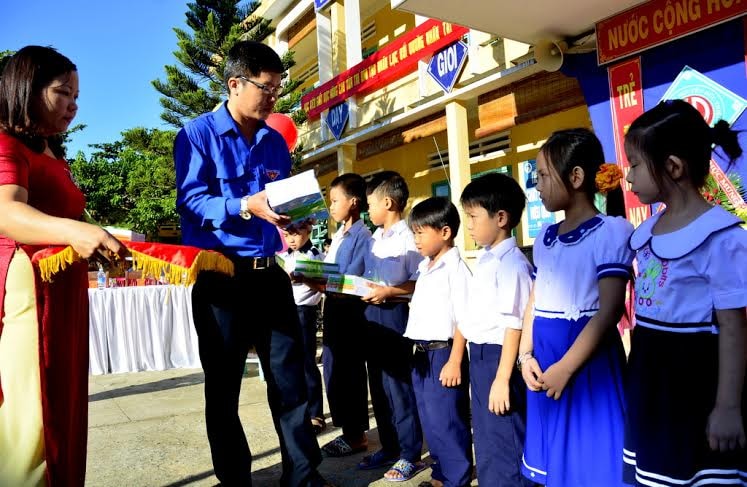 Bí thư Huyện đoàn Đại Lộc Mai Anh Sơn tặng quà cho học sinh nghèo. Ảnh: XUÂN KHÁNH