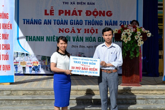 Đại diện Công ty CP Thu Bồn trao tặng 50 mũ bảo hiểm cho nhà trường.