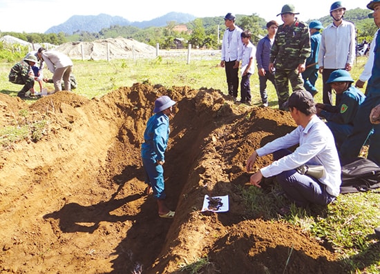 Bộ đội và dân quân khai quật các vị trí xác định hố mộ và các mẫu vật tìm được như xương, dây thép, mẫu kim loại. ảnh: P.HOÀNG