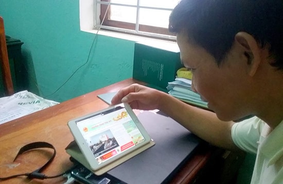 Ông Trần Vĩnh Thơ - Chủ tịch UBND xã Trà Don thao tác trên iPad để tiếp nhận thông tin từ huyện.    Ảnh: XUÂN KHÁNH