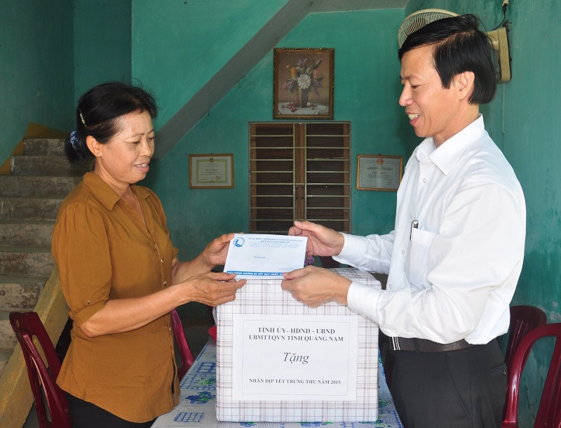 Ông Huỳnh Tấn Triều tặng quà cho đại diện Trung tâm Trẻ em khuyết tật cụm liên xã Điện Thọ. Ảnh: VINHANH