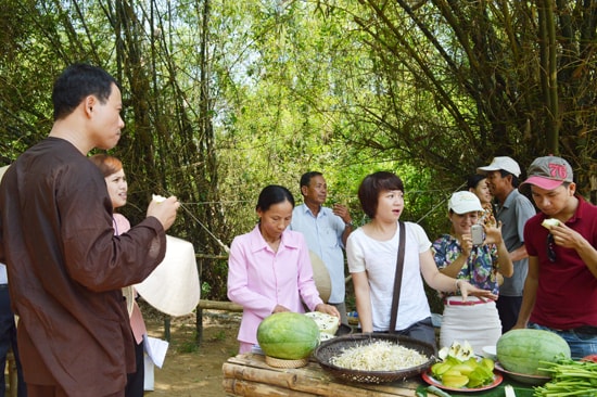 Du khách thưởng thức các sản phẩm rau sạch tại khu vườn cộng đồng Triêm Tây. Ảnh: V.LỘC