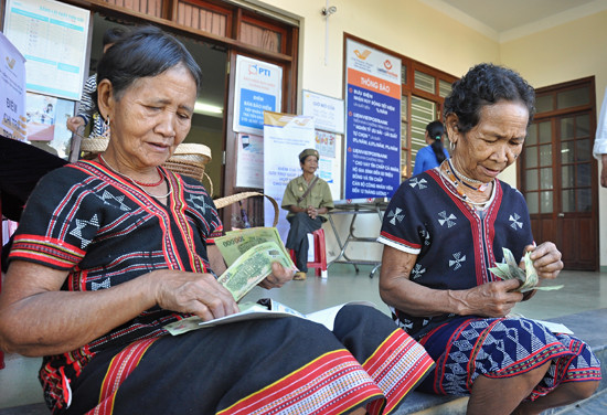 Người có công huyện Đông Giang kiểm đếm tiền trợ cấp tại Bưu điện huyện Đông Giang. 