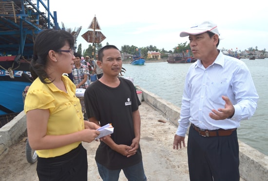 Ông Ngô Tấn (bìa phải) tìm hiểu tình hình khai thác hải sản, nhu cầu đóng mới, nâng cấp tàu cá của ngư dân. Ảnh: Q.VIỆT