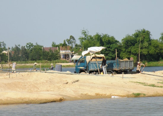 Cát khai thác trái phép được tập kết tại các bãi ven sông. Ảnh: QUANG VIỆT