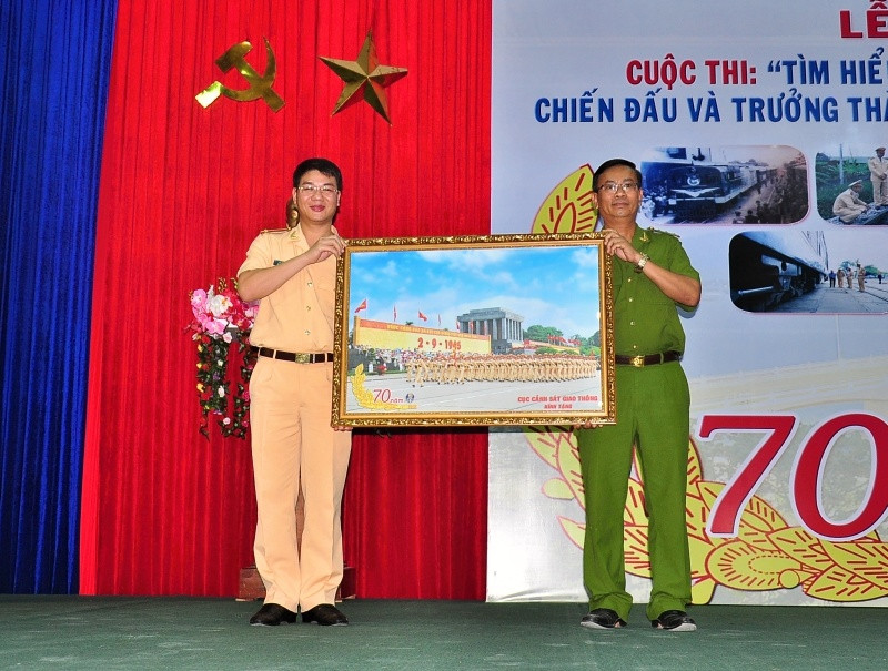 Trung tá Đỗ Thanh Bình - Phó Cục trưởng Cục CSGT tặng quà lưu niệm cho lãnh đạo nhà trường. Ảnh: VINH ANH 