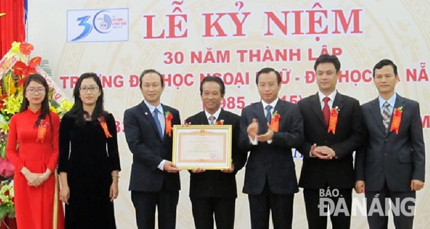 Bí thư Thành ủy Đà Nẵng Nguyễn Xuân Anh trao Bằng khen của Thủ tướng Chính phủ cho tập thể Trường ĐH Ngoại ngữ.  ảnh: NGỌC ĐOAN