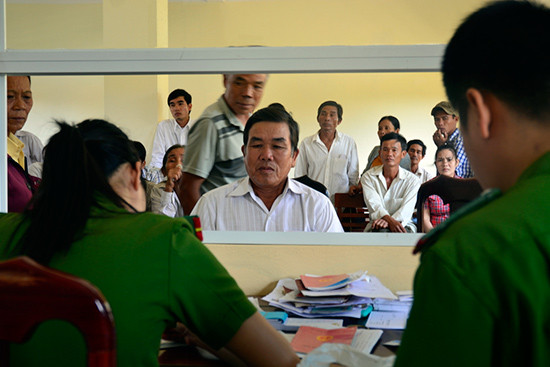 Cán bộ Công an thị xã Điện Bàn xử lý hồ sơ liên quan đến hộ khẩu cho người dân. Ảnh: XUÂN KHÁNH