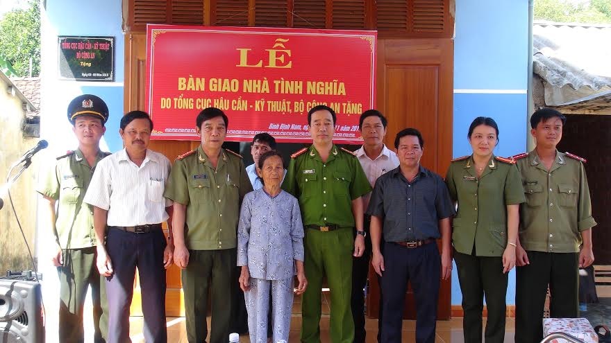 Đại tá Nguyễn Viết Lợi - Giám đốc Công an tỉnh chụp hình lưu niệm cùng gia đình tại lễ bàn giao nhà tình nghĩa. 