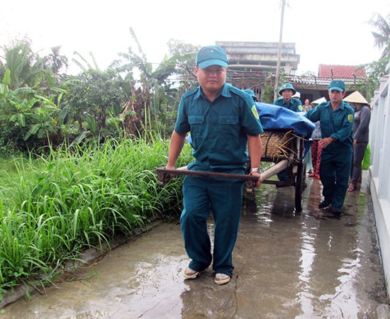 Lực lượng dân quân xã giúp dân di dời tài sản.