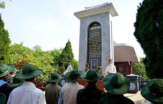 Ông Tạo thuyết minh cho khách về thân thế, sự nghiệp của cụ Huỳnh tại mộ cụ Huỳnh ở núi Thiên Ấn. Ảnh: XUÂN THỌ