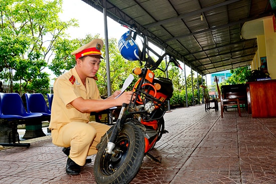 Cán bộ Đội Đăng ký, quản lý phương tiện giao thông cơ giới đường bộ kiểm tra thông số xe máy điện. Ảnh: XUÂN THỌ