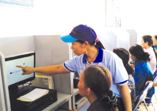 Hỗ trợ phụ nữ tìm hiểu thông tin trên internet tại Bưu điện văn hóa xã Bình Sa, huyện Thăng Bình. Ảnh: D.Q