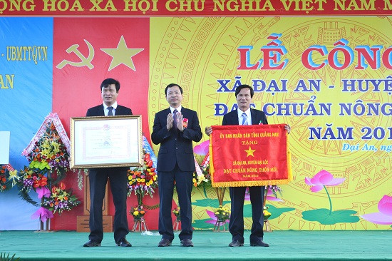 Thừa ủy nhiệm của Chủ tịch UBND tỉnh, Chủ tịch UBND huyện Đại Lộc Trần Văn Mai trao bằng công nhận và cờ thi đua cho xã Đại An.
