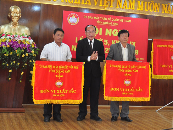 Chủ tịch Ủy ban MTTQ Việt Nam tỉnh tặng cờ Đơn vị xuất sắc cho huyện Phước Sơn và TP.Hội An. Ảnh: VINH ANH