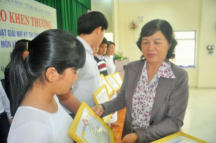 Bà Phạm Thị Minh Chiến - Chủ tịch Hội Khuyến học tỉnh trao giấy khen và tiền thưởng cho học sinh.