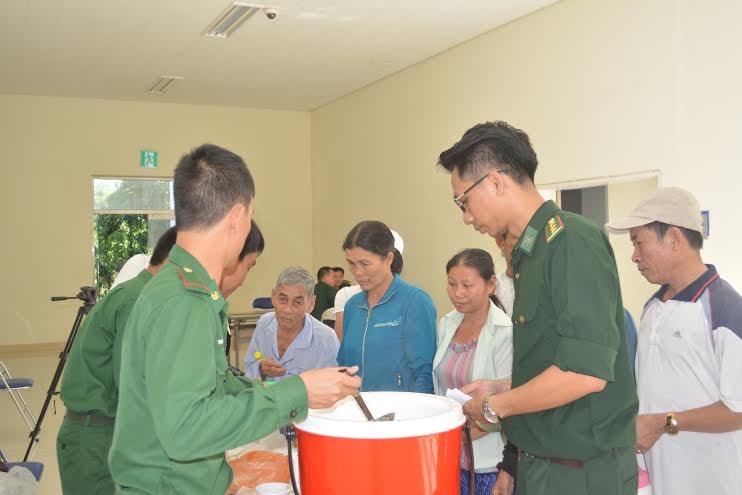 Cán bộ, chiến sĩ Đồn Biên phòng Cửa khẩu cảng Kỳ Hà phát cháo cho các bệnh nhân nghèo.