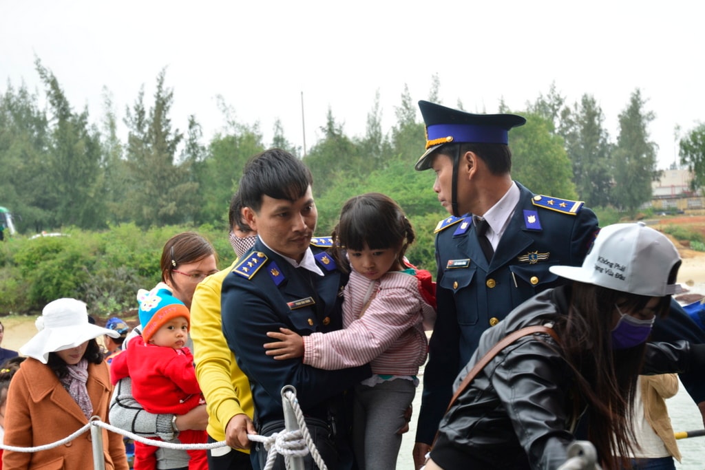 Chiến sĩ Bộ Tư lệnh Vùng Cảnh sát biển 2 bồng các em bé lên tàu. Ảnh: XUÂN THỌ